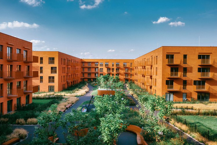 Nowoczesny kompleks apartamentów z pomarańczową elewacją, wewnętrznym dziedzińcem z zielenią i placem zabaw, widok z góry, błękitne niebo.