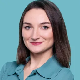 Portret uśmiechniętej kobiety w turkusowej koszuli na jednolitym, jasnym, turkusowym tle.