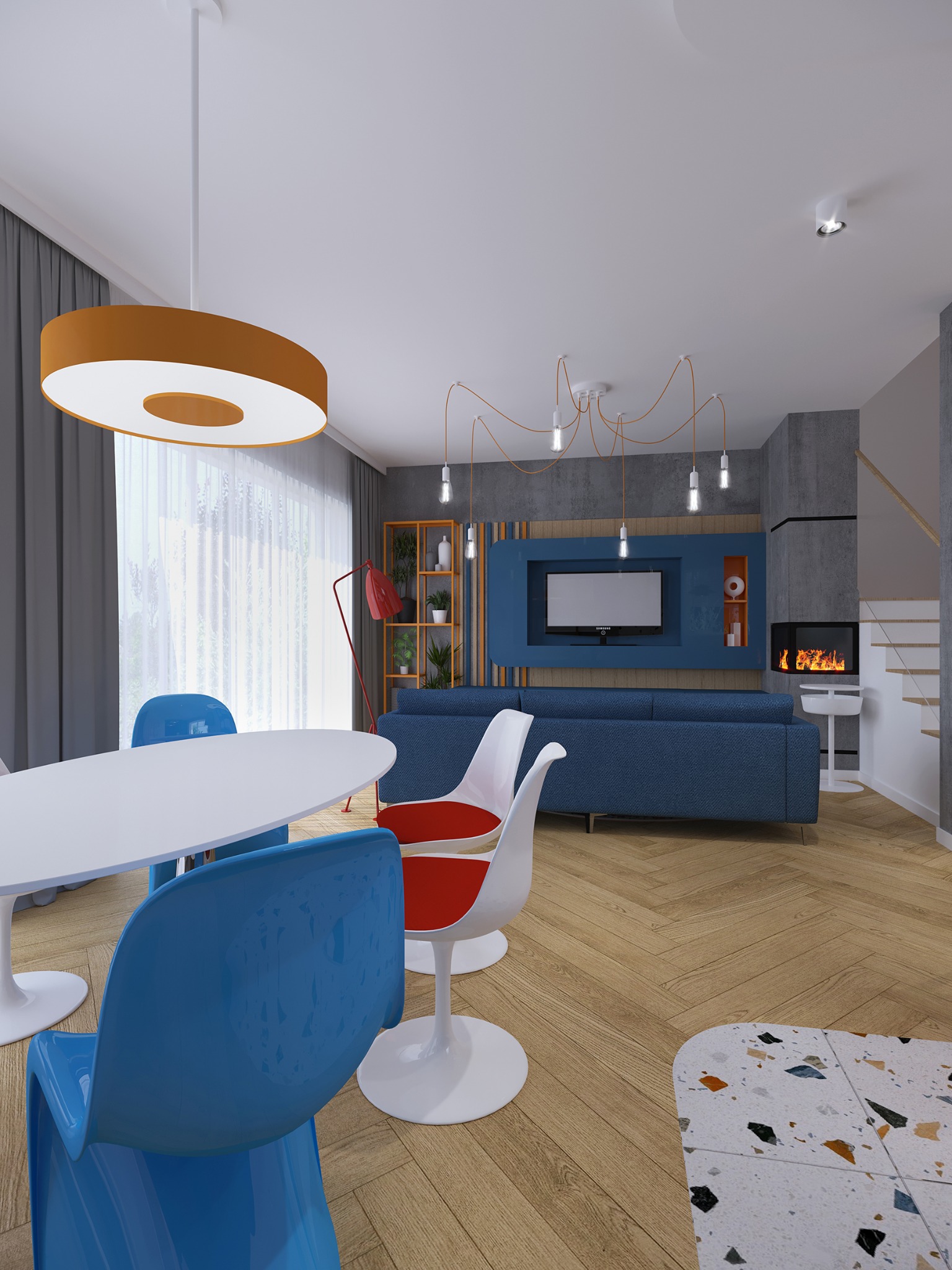 Nowoczesny salon w Warszawie z niebieską sofą, białym stołem i kolorowymi krzesłami, oświetlony wiszącą lampą w kształcie okręgu i lampami na kablach, z kominkiem i schodami w tle.