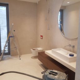 PAECH NEW HOME - Łazienka w trakcie prac wykończeniowych: widoczna drabina, toaleta bez deski, nowoczesna umywalka nablatowa z szafką, okrągłe lustro, wiszące lampy i odkurzacz przemysłowy Bosch na pierwszym planie.