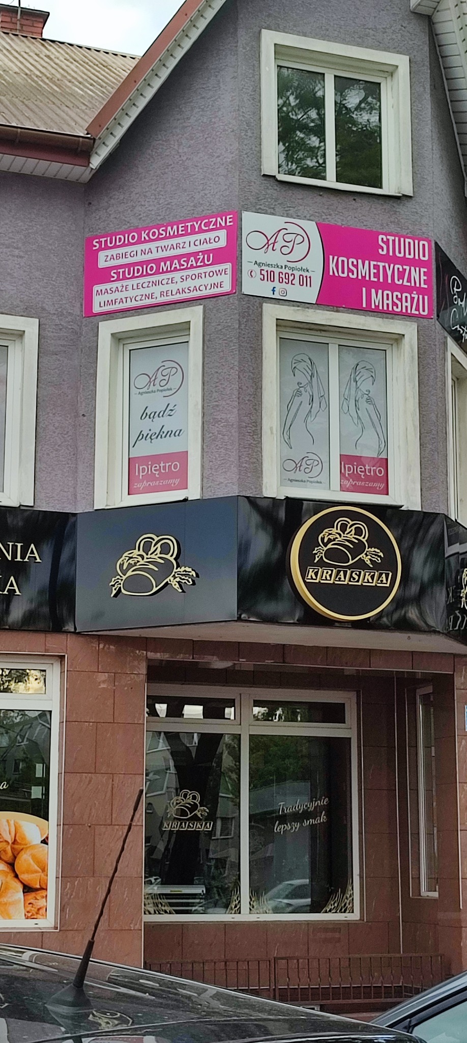 Zewnętrzny widok budynku z szyldami salonu kosmetycznego i masażu 'Studio Kosmetyczne i Masażu' oraz 'Studio Masażu', z ofertą zabiegów na twarz i ciało, masaży leczniczych i sportowych, oraz logo...