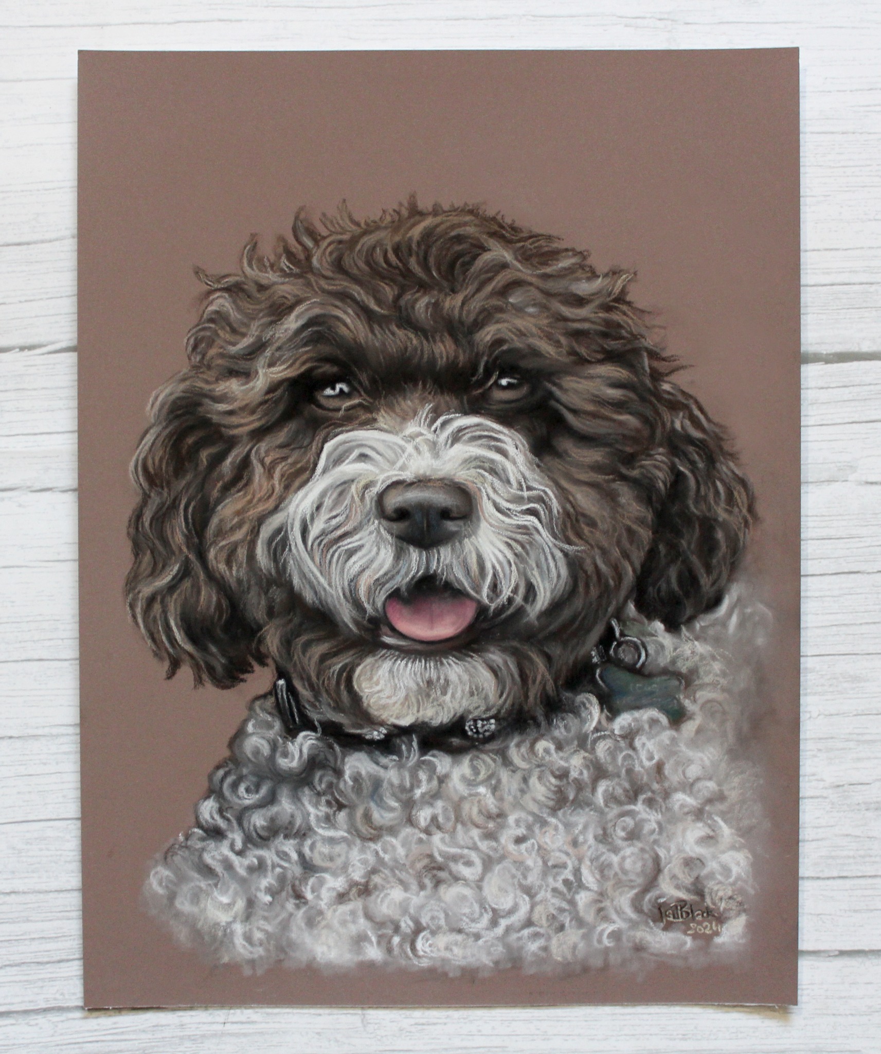 Portret psa rasy Lagotto Romagnolo, namalowany pastelami na brązowym papierze. Widoczna sygnatura artysty w prawym dolnym rogu.