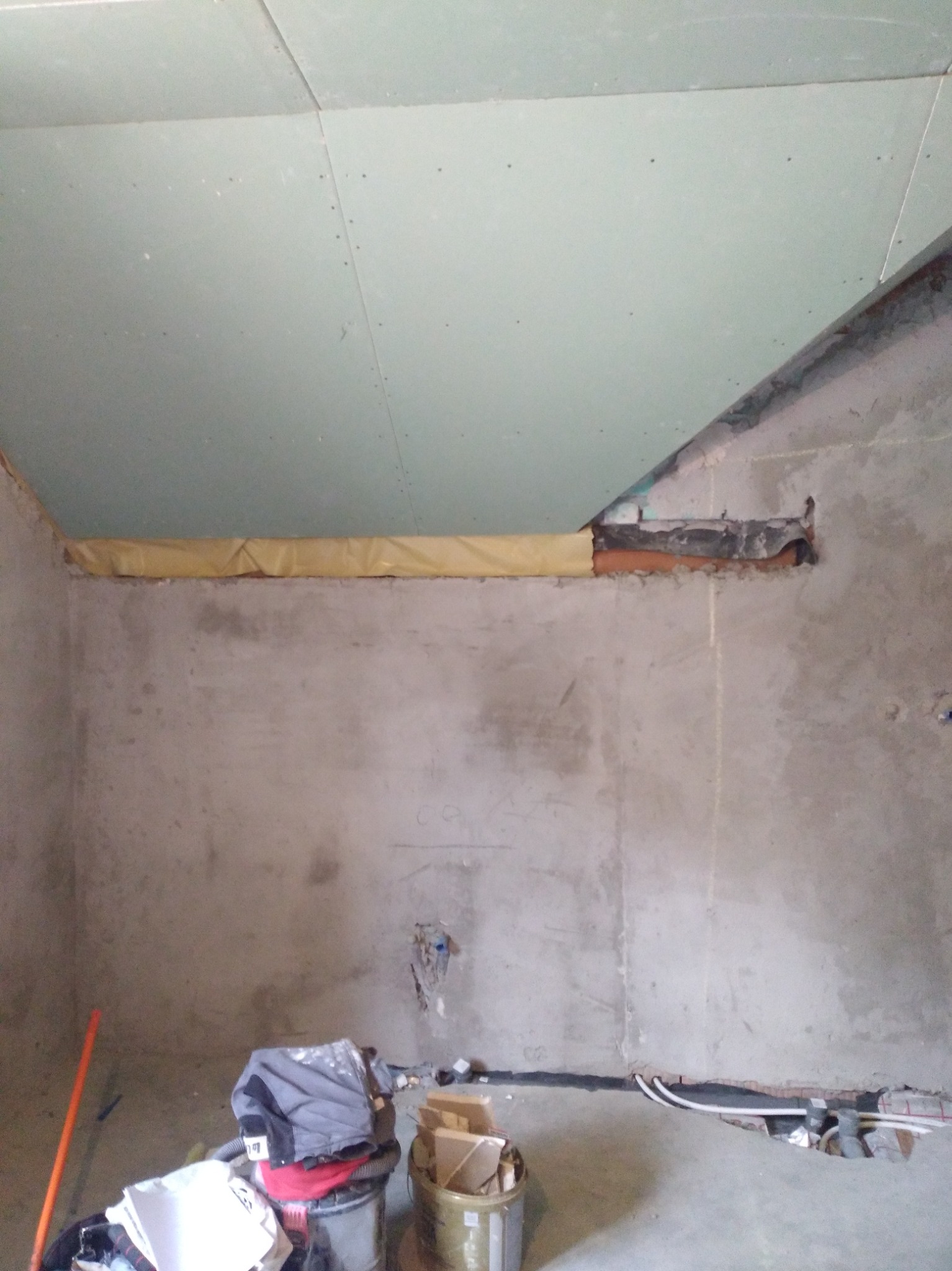 Montaż płyty karton gips na suficie w trakcie remontu w Prabutach. Widoczne niedoskonałości ściany i instalacje.