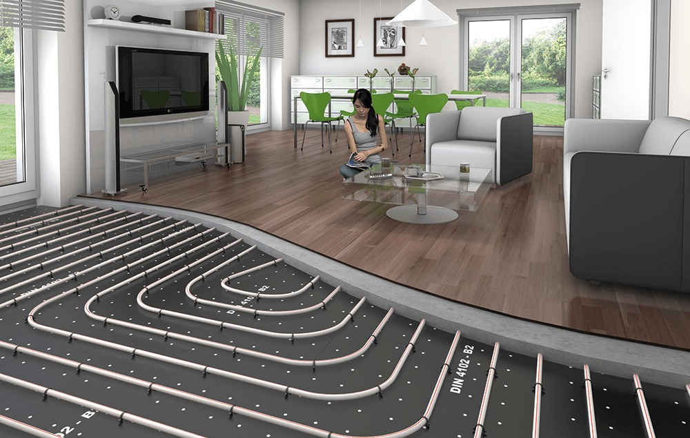 Instalacja ogrzewania podłogowego w nowoczesnym salonie z widocznymi rurami grzewczymi na czarnej macie izolacyjnej z oznaczeniami DIN 4102-B2, częściowo zakrytymi drewnianą podłogą, z siedzącą...