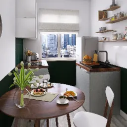 Kompaktowa kuchnia w bieli i butelkowej zieleni z okrągłym drewnianym stołem, na którym leżą naleśniki z owocami, danie obiadowe i filiżanka kawy, widok na miasto za oknem.