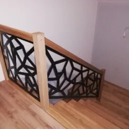 Nowoczesne schody metalowe z geometrycznym wzorem balustrady, drewniane stopnie i poręcz, widok z góry