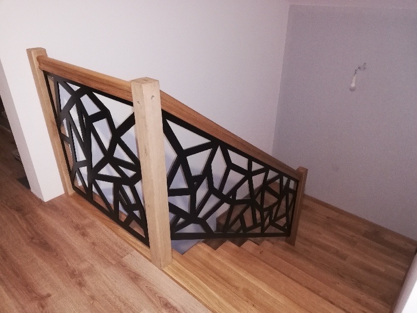 Nowoczesne schody metalowe z geometrycznym wzorem balustrady, drewniane stopnie i poręcz, widok z góry