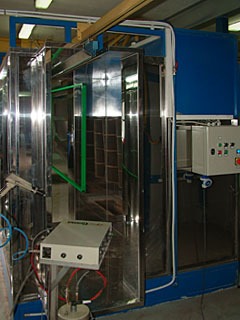 Komora do nakładania powłok na metalowe elementy, widoczne okablowanie i panel sterowania, oświetlenie górne.