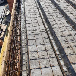 Wieniec stropowy w szalunku zbrojony stalą, widoczne betonowe pustaki stropowe i przygotowane zbrojenie.