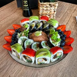 Wykwintna kompozycja sushi z owocami: rolki z kiwi, truskawkami, łososiem i sałatą, otoczone świeżymi truskawkami i borówkami, podane na drewnianym stole obok butelki sosu sojowego i plecionego...