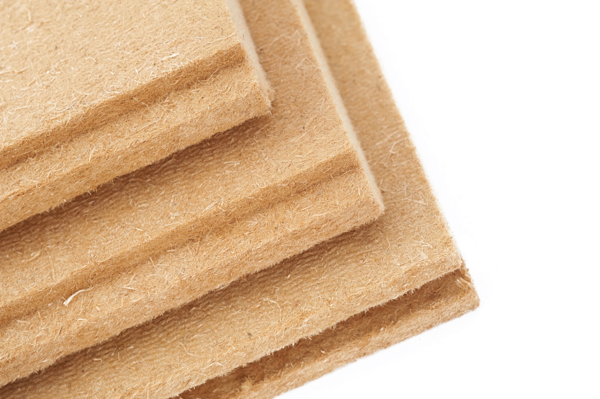 Stos trzech płyt z tarcicy budowlanej o widocznej strukturze włókien drzewnych na białym tle.