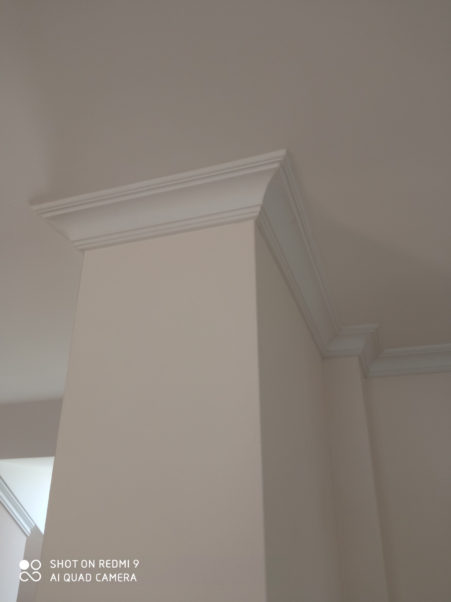 Dekoracyjny, biały gzyms wieńczący ścianę i sufit, widoczny z perspektywy pod kątem, podkreślający architektoniczne detale wnętrza.