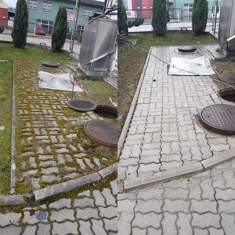 Zaniedbana kostka brukowa z mchem, otwarty właz kanalizacyjny i przewrócona metalowa obudowa urządzenia na trawniku przed budynkiem.