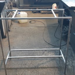 Astern - Szkielet metalowej konstrukcji spawanej z profili, widoczny w warsztacie obróbki metali, z narzędziami i materiałami w tle.