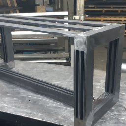 Astern - Stalowa konstrukcja ramy z trzema poprzeczkami, spawana, z widocznymi śladami obróbki, na tle warsztatu.