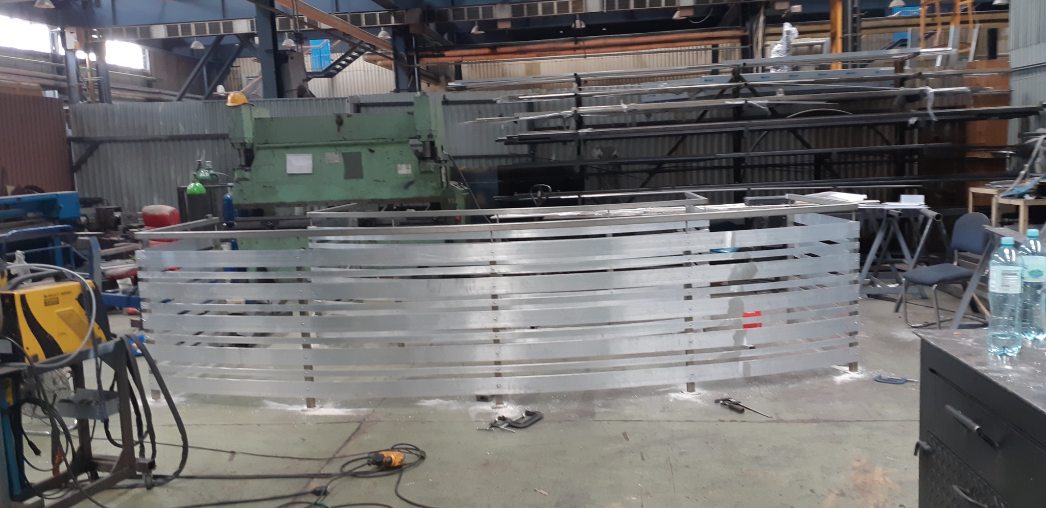 Wytwarzanie segmentu balustrady z profili aluminiowych w hali produkcyjnej, widoczne narzędzia i maszyny.