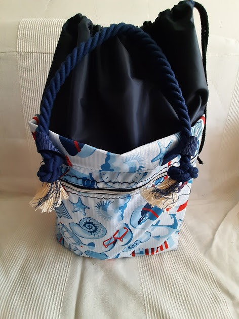 Torba-worek z motywem morskim (muszle, kotwice) uszyta we Wrocławiu, z granatowym sznurkiem i frędzlami, widoczna na kremowym tle.