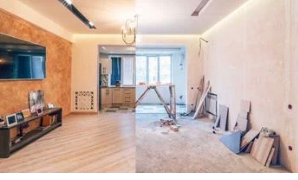 Pokój podzielony na dwie części: wykończona część z telewizorem, półką i dekoracyjną ścianą oraz część w trakcie prac z rusztowaniem, materiałami budowlanymi i surową ścianą.