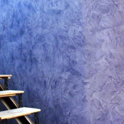 VIP Interior Decor - Ściana z dekoracyjną fakturą w odcieniach fioletu i błękitu, widoczne drewniane schody z metalowymi elementami.