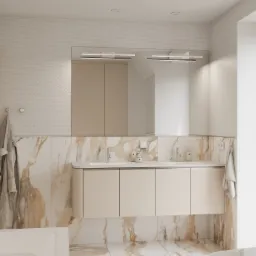 Jasna łazienka z marmurowymi akcentami: podwójna umywalka z beżową szafką, mozaika na ścianach, oświetlenie LED nad lustrem, ręcznik i szlafrok na wieszakach.