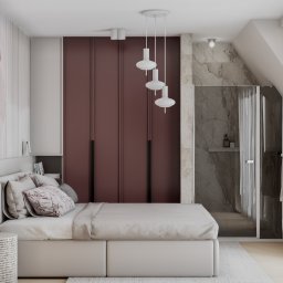 DESIGN ME Studio - Elegancka sypialnia z łazienką: białe łóżko z wzorzystą poduszką, bordowa szafa w zabudowie, szklana kabina prysznicowa i designerskie lampy wiszące.