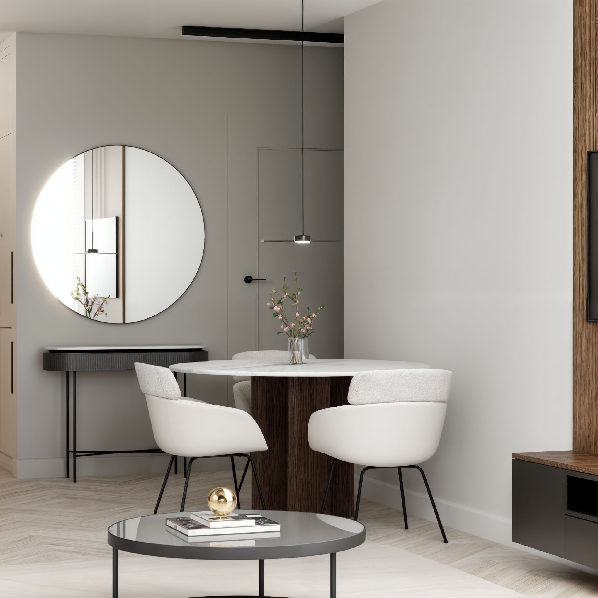 Nowoczesna aranżacja wnętrza: okrągłe lustro z podświetleniem, stół z kwiatami, białe krzesła na tle parkietu w jodełkę i szarej ściany z drewnianym akcentem.
