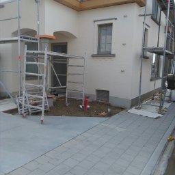 A-Z PIOTR-BUD - Dom jednorodzinny w trakcie malowania elewacji, widoczne rusztowania i świeżo pomalowana ściana w jasnym odcieniu.