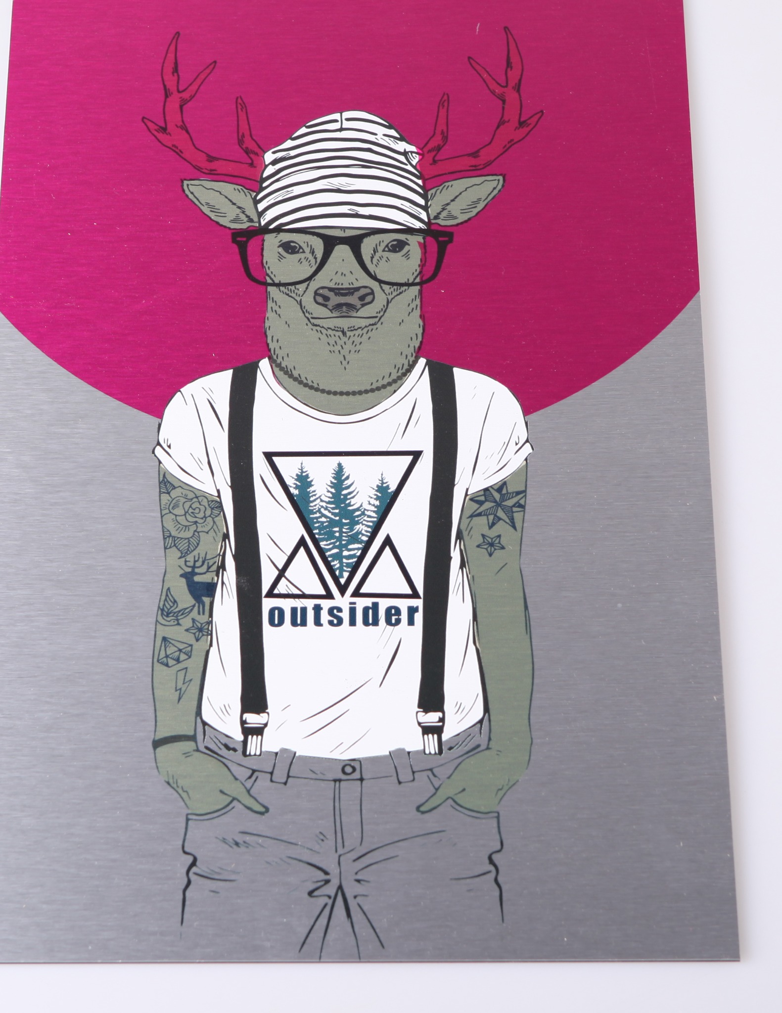 Ilustracja przedstawia antropomorficznego jelenia w czapce, okularach i koszulce z nadrukiem drzew, na metalowej powierzchni z różowym tłem.