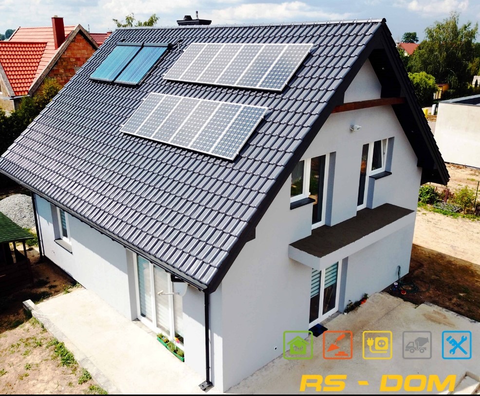 Nowoczesny dom jednorodzinny z szarą dachówką i panelami słonecznymi na dachu, widok z góry.