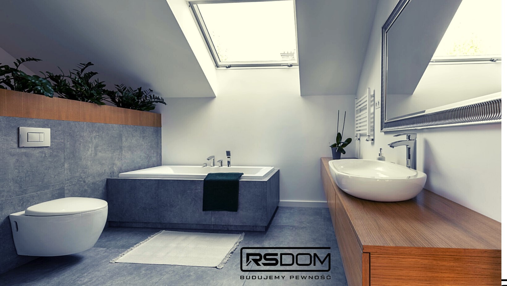 Nowoczesna łazienka na poddaszu z oknami dachowymi: wanna obudowana szarą płytką, podwieszana toaleta, umywalka nablatowa na drewnianym blacie, rośliny w donicach, szary dywanik i logo firmy RSDOM...