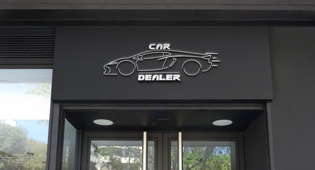 Eleganckie, podświetlane logo salonu samochodowego na czarnym tle nad wejściem, przedstawiające kontur sportowego auta i napis 'CAR DEALER'.