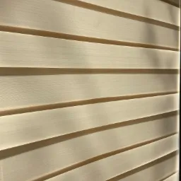 Beżowe żaluzje wewnętrzne typu dzień-noc, z widoczną delikatną strukturą materiału i subtelnymi cieniami. Listwy ułożone poziomo, częściowo zasłonięte.