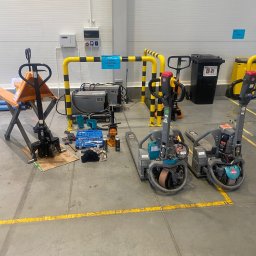 FS-Lechowicz Krzysztof Lechowicz - Warsztatowy widok na rozłożone narzędzia i wózki paletowe elektryczne w trakcie naprawy, z widocznymi elementami diagnostycznymi i częściami zamiennymi.