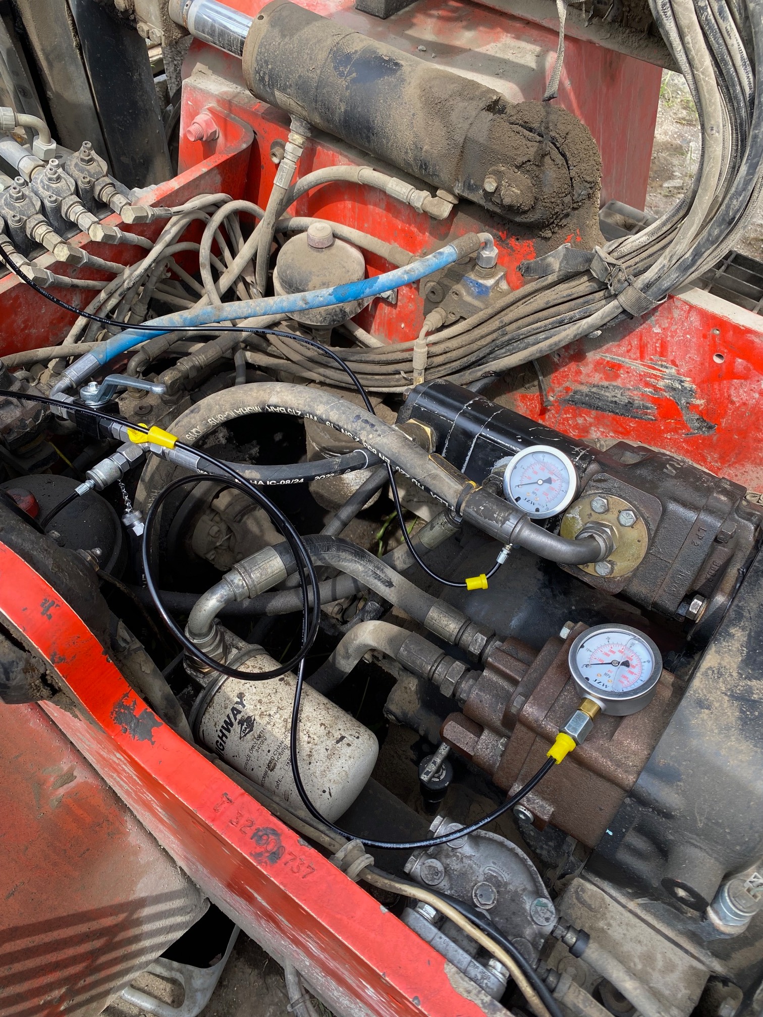 Silnik wózka widłowego poddawany diagnostyce, widoczne manometry podłączone do przewodów hydraulicznych, filtr oleju marki HIGHWAY.