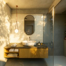 Obszary Studio - Nowoczesna łazienka z owalnym lustrem, wiszącą szafką z umywalką i kabiną prysznicową. Ściany w jasnych płytkach, oświetlenie punktowe, pralka z lewej strony.