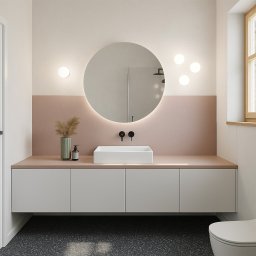 Obszary Studio - Minimalistyczna łazienka z okrągłym lustrem podświetlanym LED, białą umywalką nablatową i szafką w kolorze złamanej bieli. Akcenty w odcieniach pudrowego różu i czarne matowe baterie.