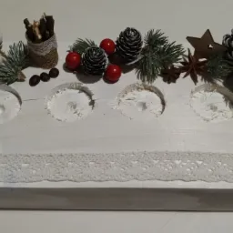 Dekoracyjny, ręcznie robiony świecznik z drewna, ozdobiony szyszkami, gałązkami świerku, kokardą jutową z koronką i cynamonem, w stylu rustykalnym.