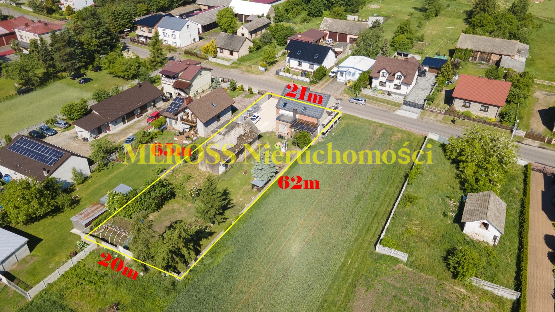 Zdjęcie z lotu ptaka przedstawia dom z działką, obrysowaną żółtą linią z wymiarami 21m x 62m x 20m, w tle widoczne inne domy i zieleń, nałożony półprzezroczysty tekst 'MEROSS Nieruchomości'.