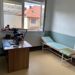 IDmal - Jasne wnętrze gabinetu lekarskiego po odświeżeniu: biurko z laptopem, kozetka z zielonym podkładem, ściany pomalowane na biało z turkusowym pasem na dole.