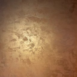 N.P.Air.Sp.Zo.O. - Ściana z efektem dekoracyjnym w odcieniach brązu i złota, z wyraźną fakturą i nierównomiernym oświetleniem.