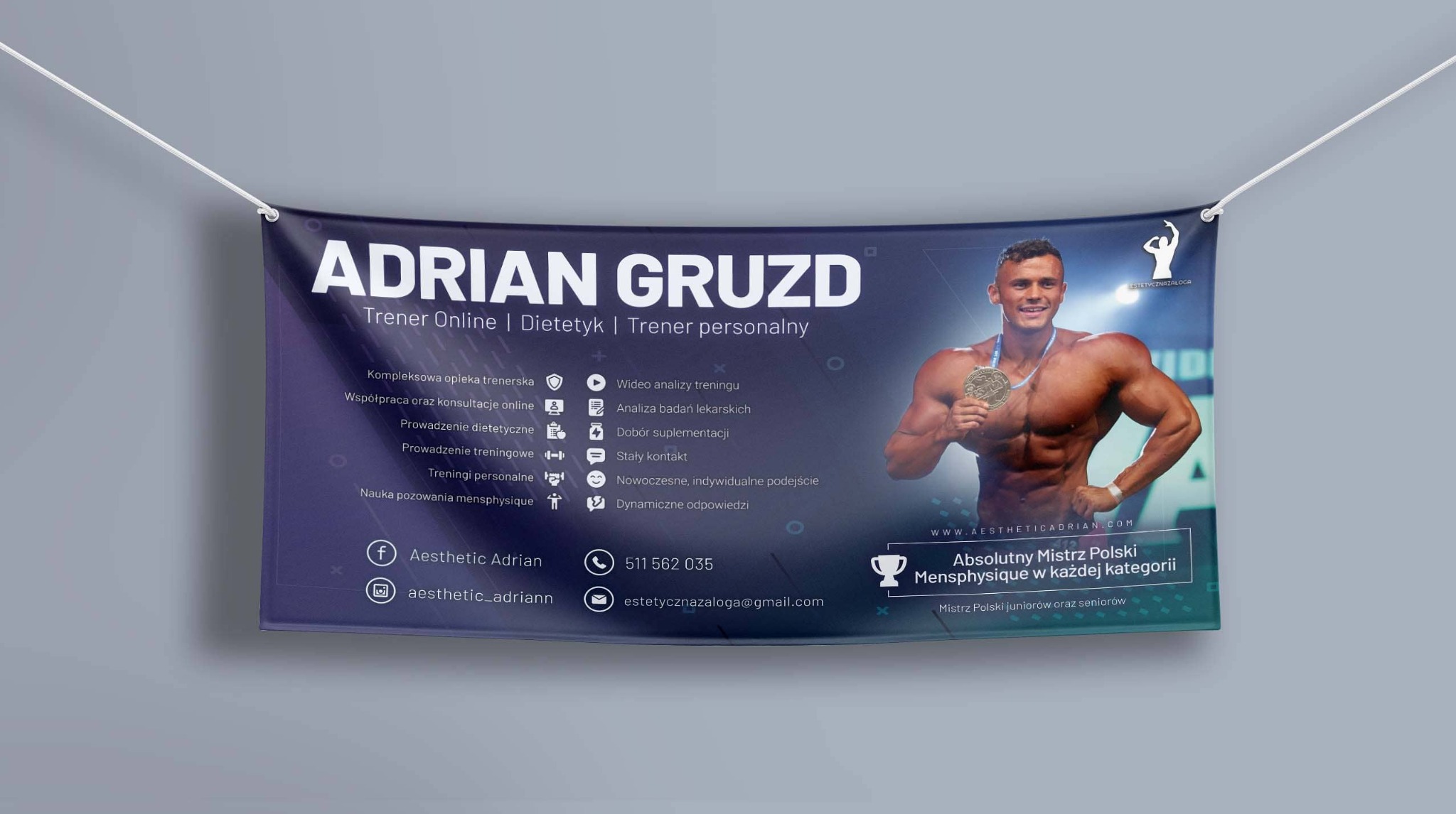 Baner reklamowy z wizerunkiem trenera personalnego Adriana Gruzda, prezentujący jego usługi online i stacjonarne, z informacjami kontaktowymi i odznaczeniami sportowymi.