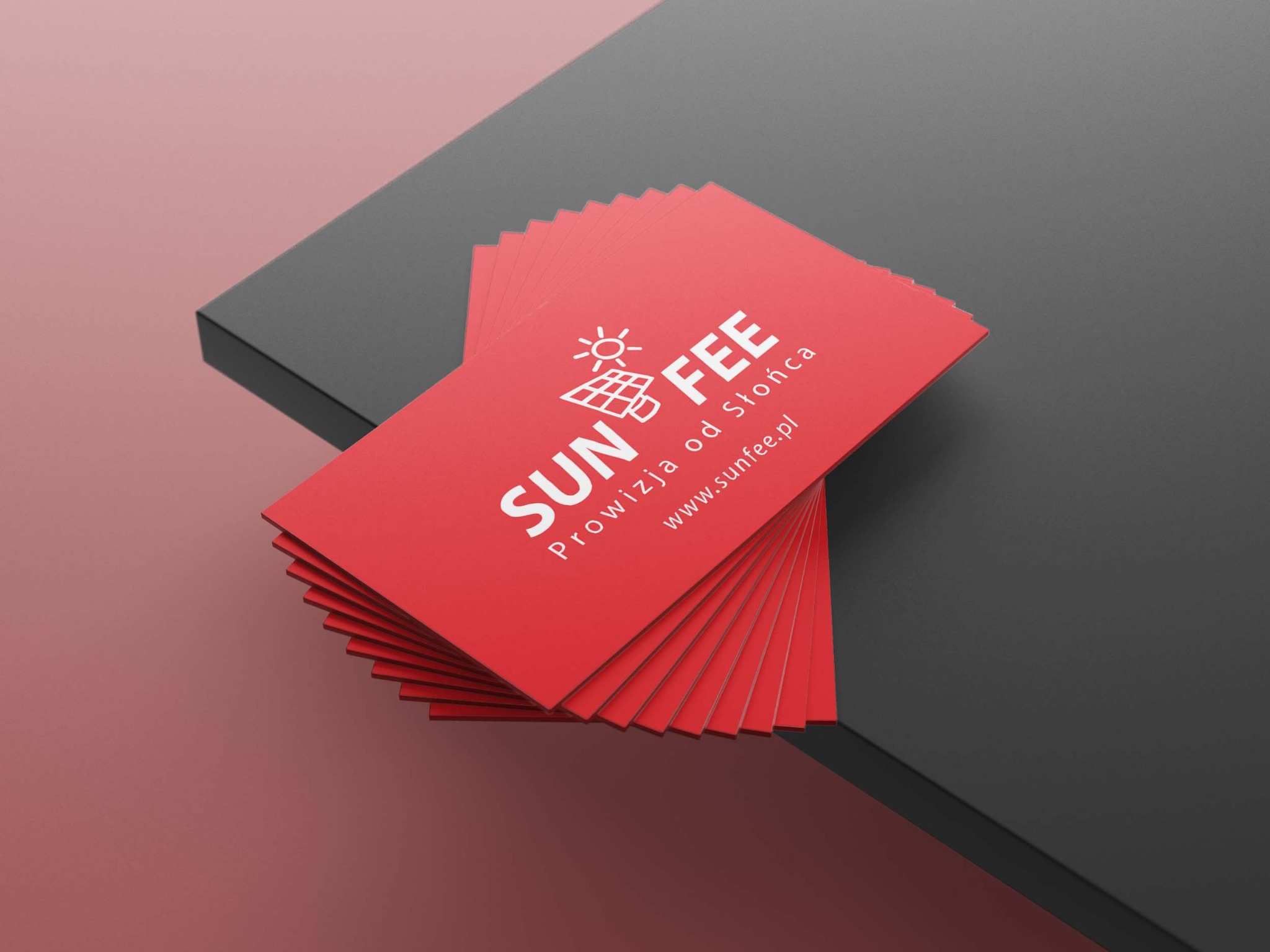 Stos czerwonych wizytówek SunFee z białym logo i informacjami o firmie na tle gradientu czerwieni i szarości.