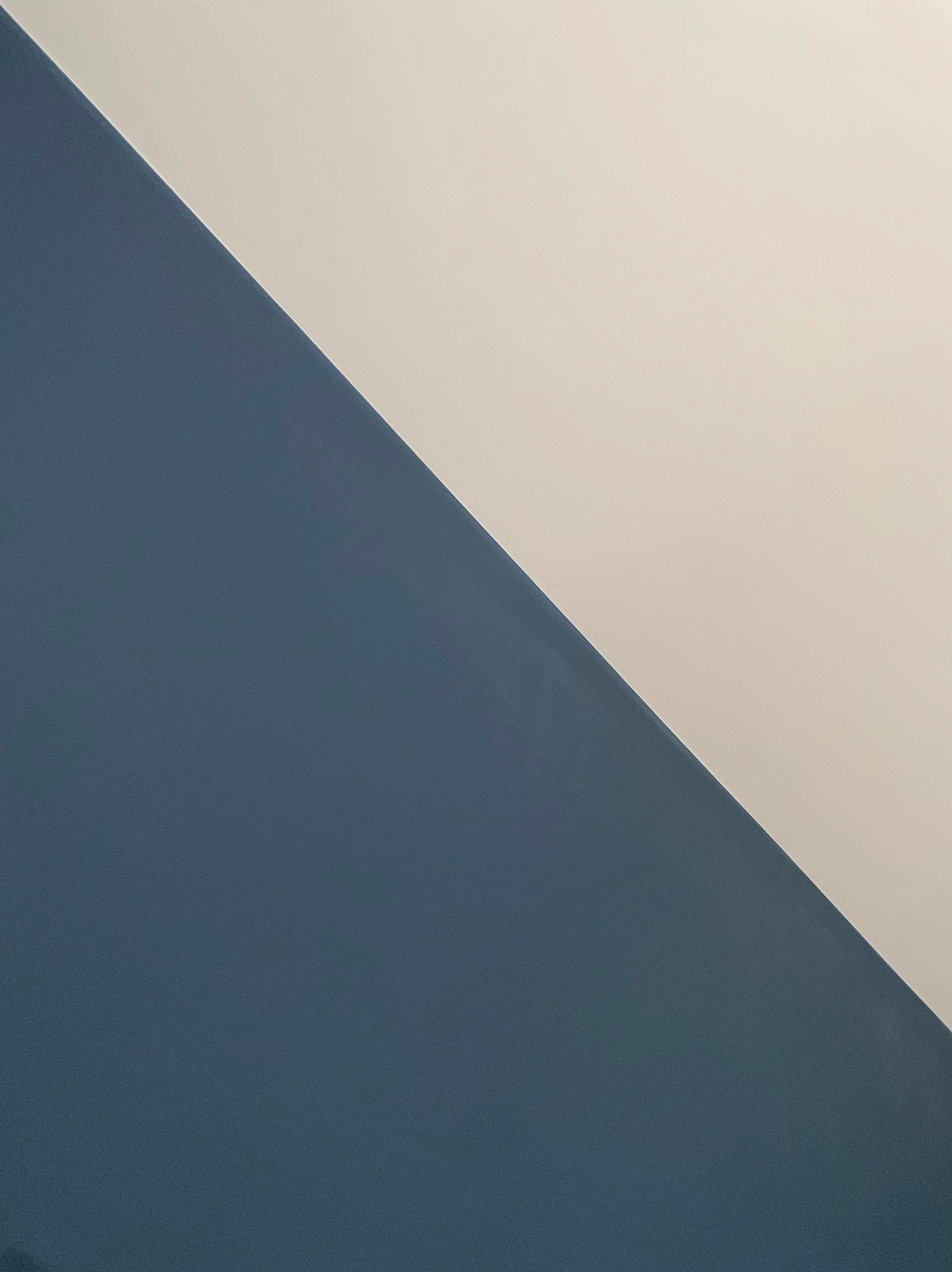 Ściana pomalowana w połowie na granatowo, w połowie na kremowo, z widoczną fakturą farby.