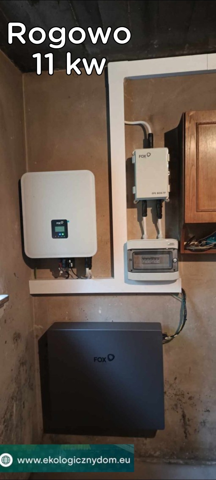 Instalacja fotowoltaiczna o mocy 11 kW w Rogowie, obejmująca inwerter, skrzynkę przyłączeniową i magazyn energii firmy Fox. Elementy zamontowane na ścianie wewnątrz budynku.