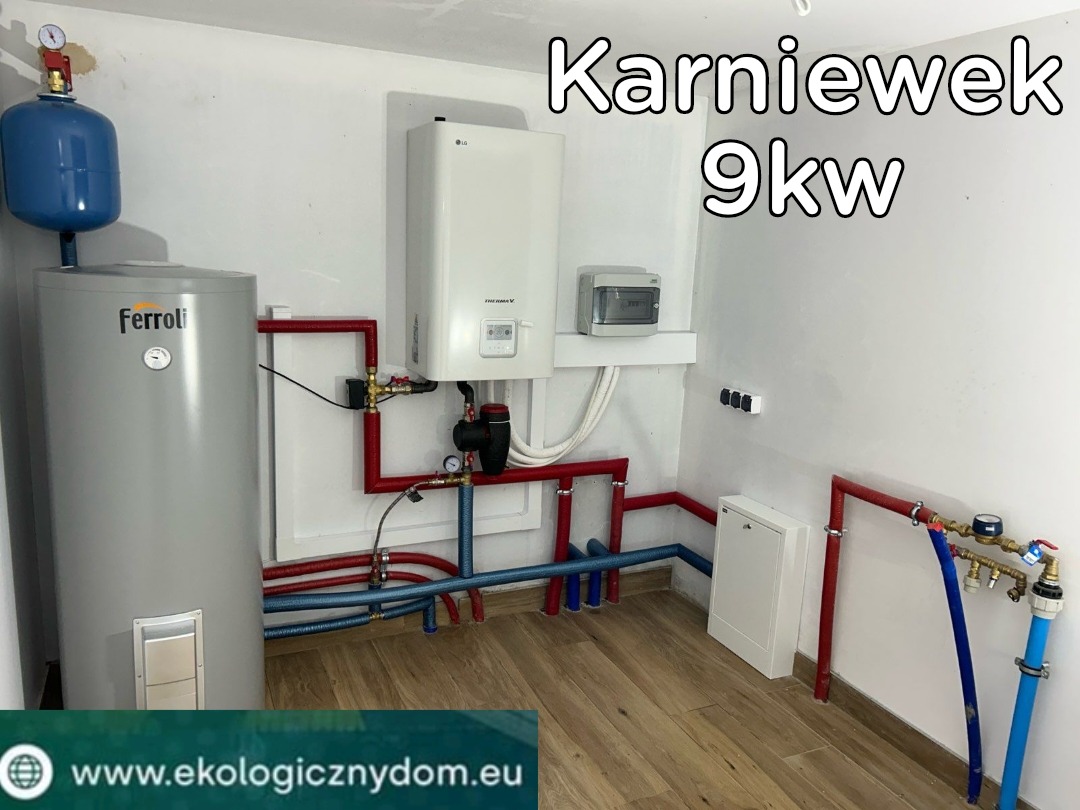 Instalacja grzewcza z szarym zbiornikiem Ferroli, białym piecem LG Therma V i widocznymi rurami w kolorach czerwonym i niebieskim, zamontowana w pomieszczeniu z panelami podłogowymi.