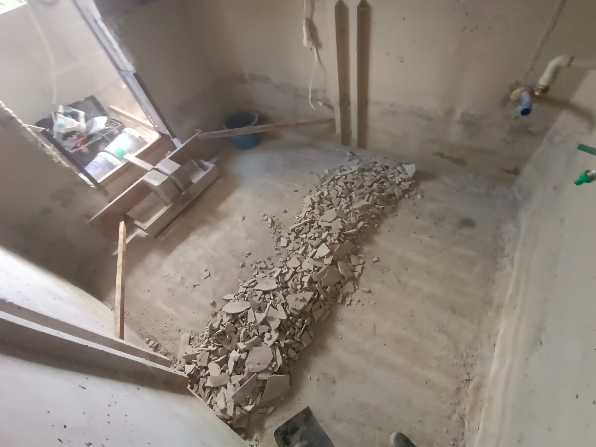 Piwnica w trakcie prac hydroizolacyjnych: widoczne schody, posadzka i gruz, przygotowywane do dalszych etapów prac.