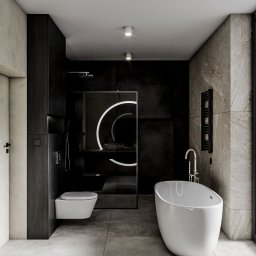 Jagiełło di Office Studio Projektowe - Minimalistyczna łazienka z czarną ścianą, kabiną prysznicową z podświetlanym lustrem i wolnostojącą wanną. Szara podłoga z płytek imitujących beton.