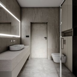Jagiełło di Office Studio Projektowe - Nowoczesna łazienka z podświetlanym lustrem, umywalką nablatową i kabiną prysznicową. Minimalistyczny design, stonowana kolorystyka, płytki imitujące kamień.