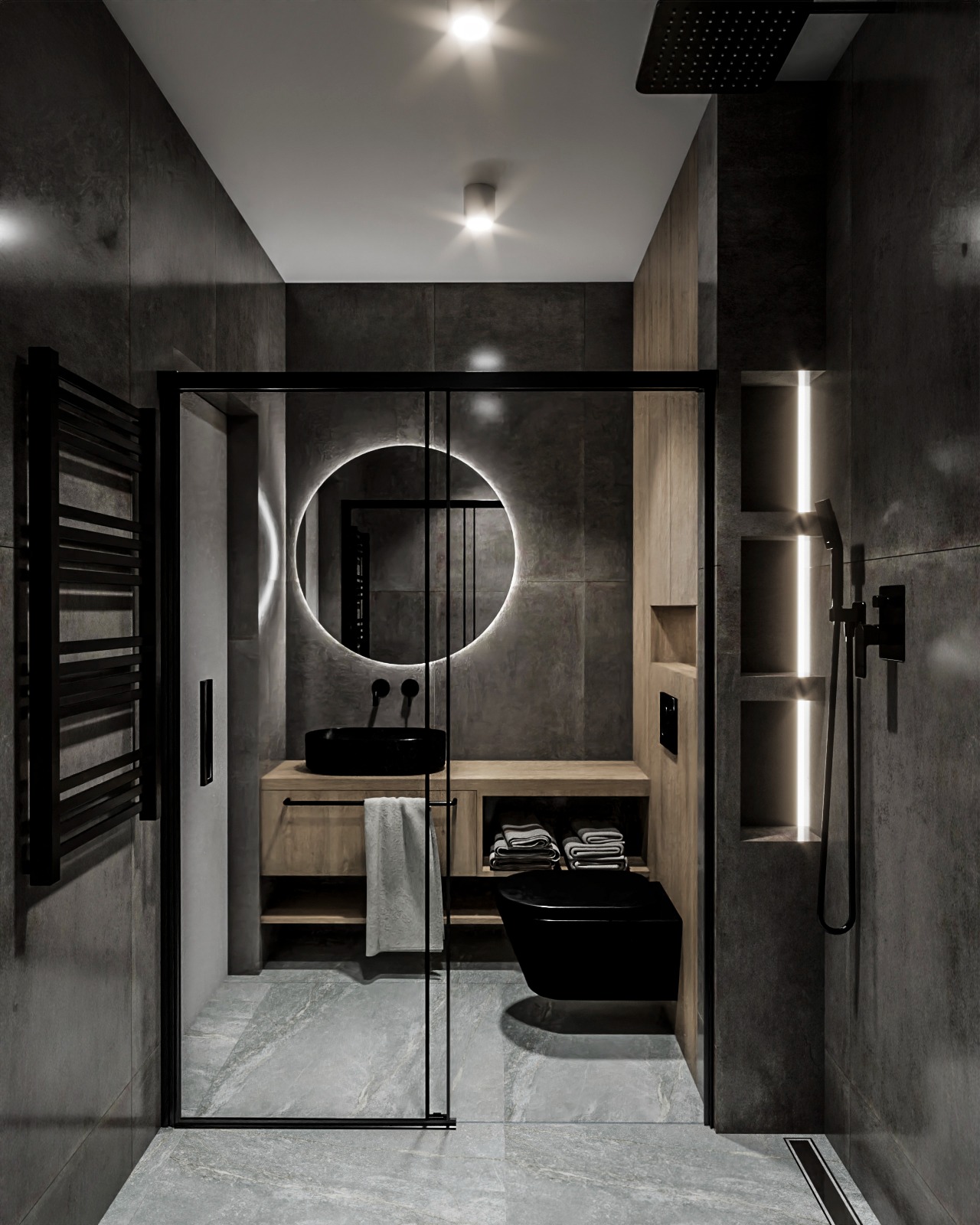 Nowoczesna łazienka z czarną armaturą, podświetlanym lustrem i szarymi płytkami. Widoczna kabina prysznicowa z czarnymi ramami i drewniane elementy wyposażenia.