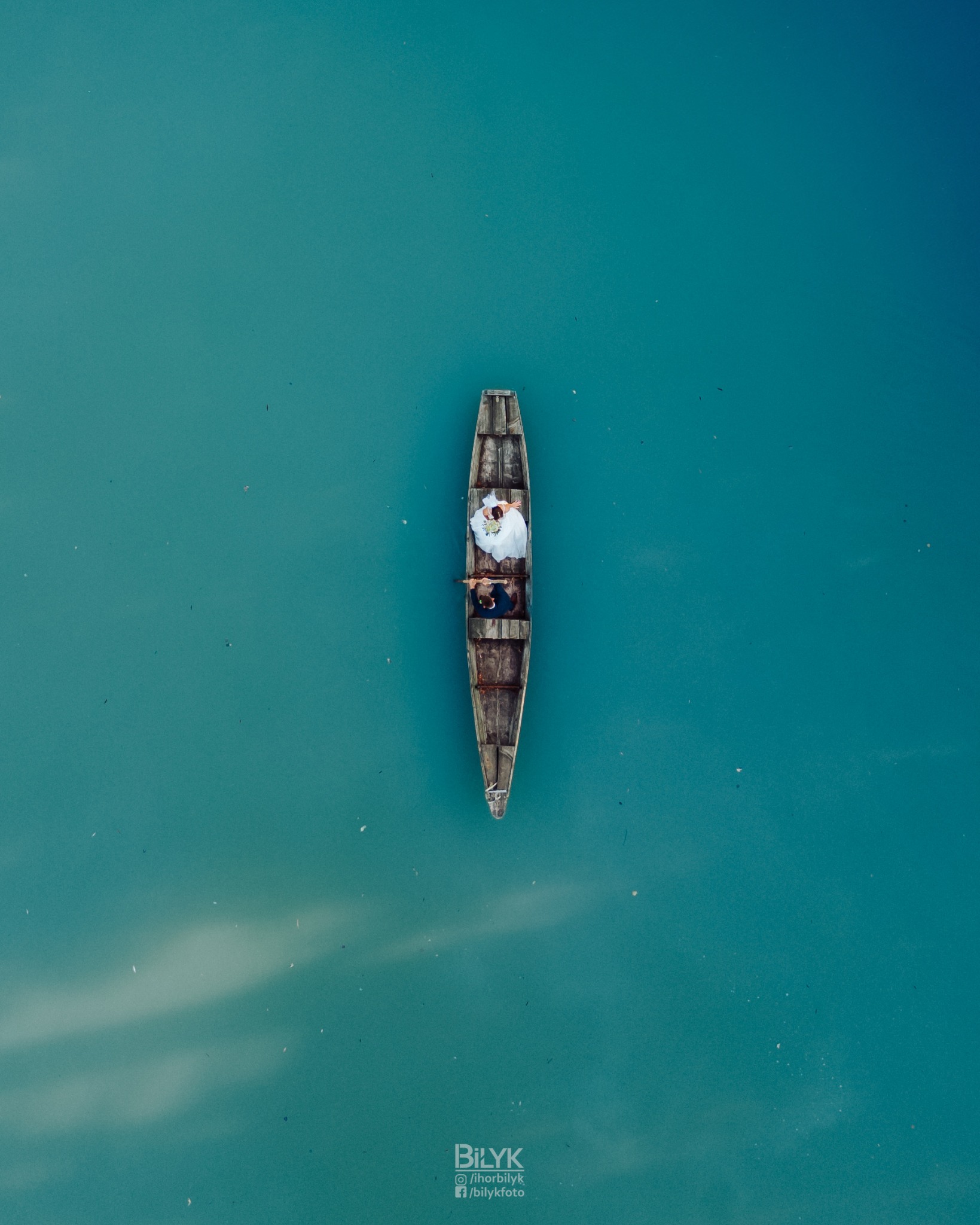 Zdjęcie z lotu ptaka: Nowożeńcy w drewnianej łodzi na turkusowej wodzie.